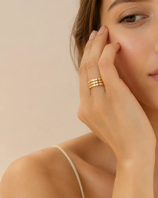 Frau mit der Hand am Gesicht. Am Finger trägt sie einen vergoldeten Ring von VARALIDA.